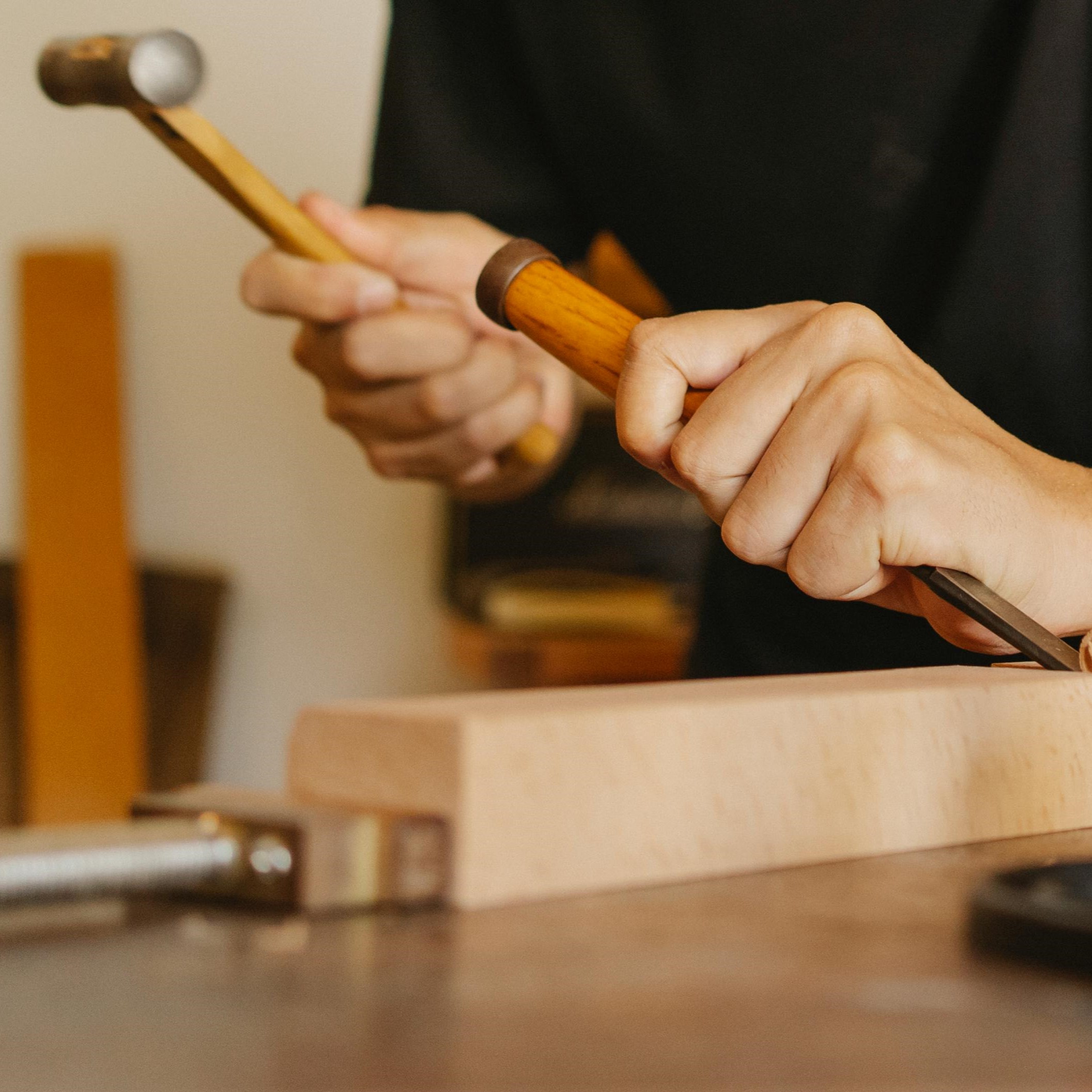 Person using a hammer and chisel on woodworking project